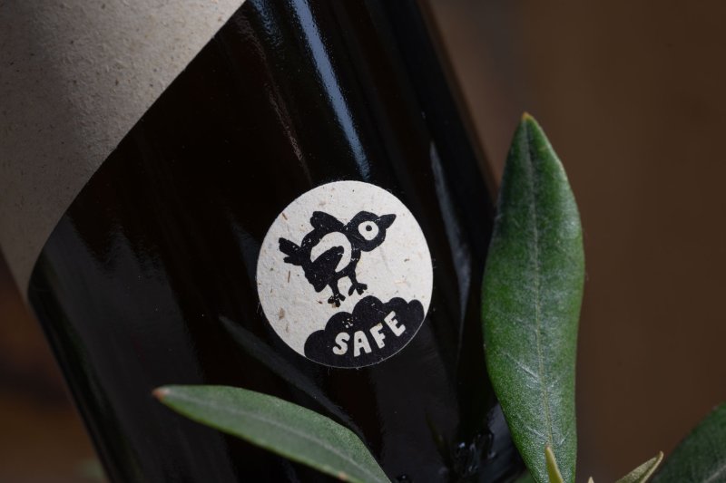 BIRDsafe-Siegel auf einer Oelea-Olivenölflasche mit Olivenzweigen