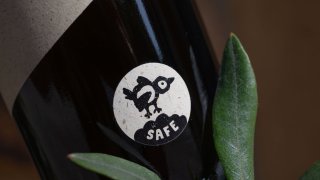 BIRDsafe-Siegel auf einer Oelea-Olivenölflasche mit Olivenzweigen